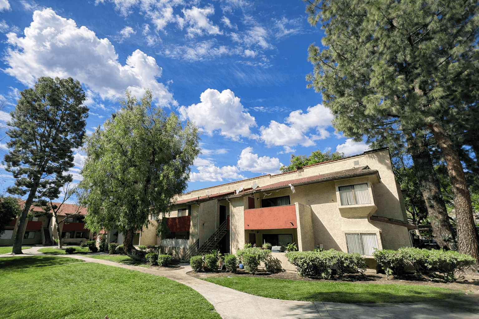 A row of houses with trees in front.